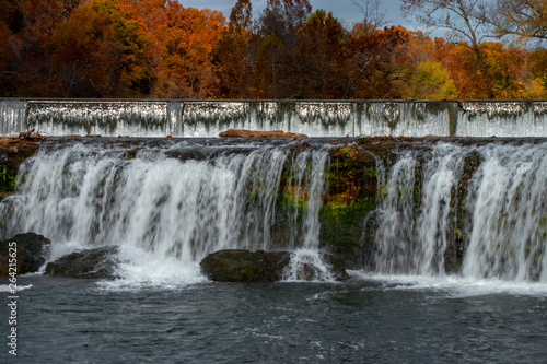 Fototapeta Naklejka Na Ścianę i Meble -  Vivid fall colors surround this fabulous waterfall scene in the Ozarks in Joplin, Missouri.