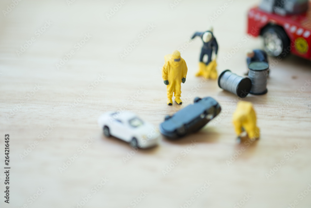 Figure of firefighter team in hazmat suit standing next to car Figure of firefighter team in hazmat suit standing next to car