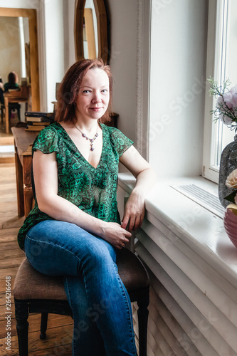 Portrait of a woman sitting by the window in the room