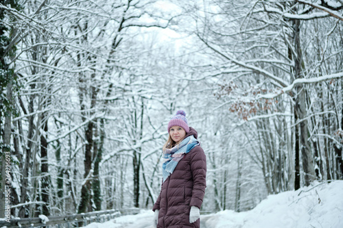 Beautiful blond girl posing in snow mountain forest