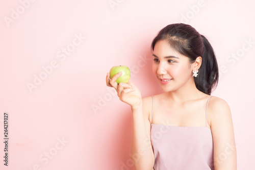 Wallpaper Mural Healthy girl eating green apple on pink  background Torontodigital.ca