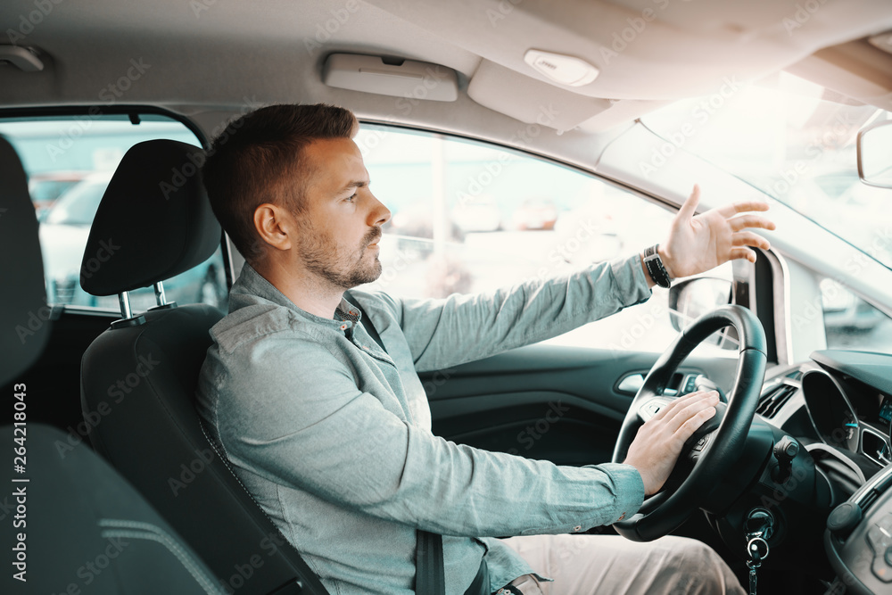 Nervous handsome Caucasian man getting stacked in traffic while driving his car. Nervous handsome Caucasian man getting stacked in traffic while driving his car.