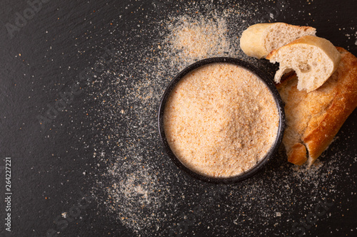 Cuadro en lienzo Food ingredients homemade organic bread crumbs in black ceramic bowl on black sl