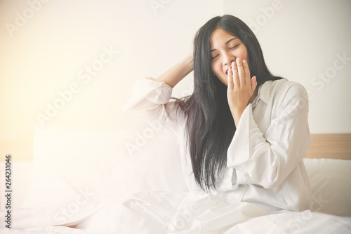 Beautiful young woman wake up and yawn in the morning at bedroom