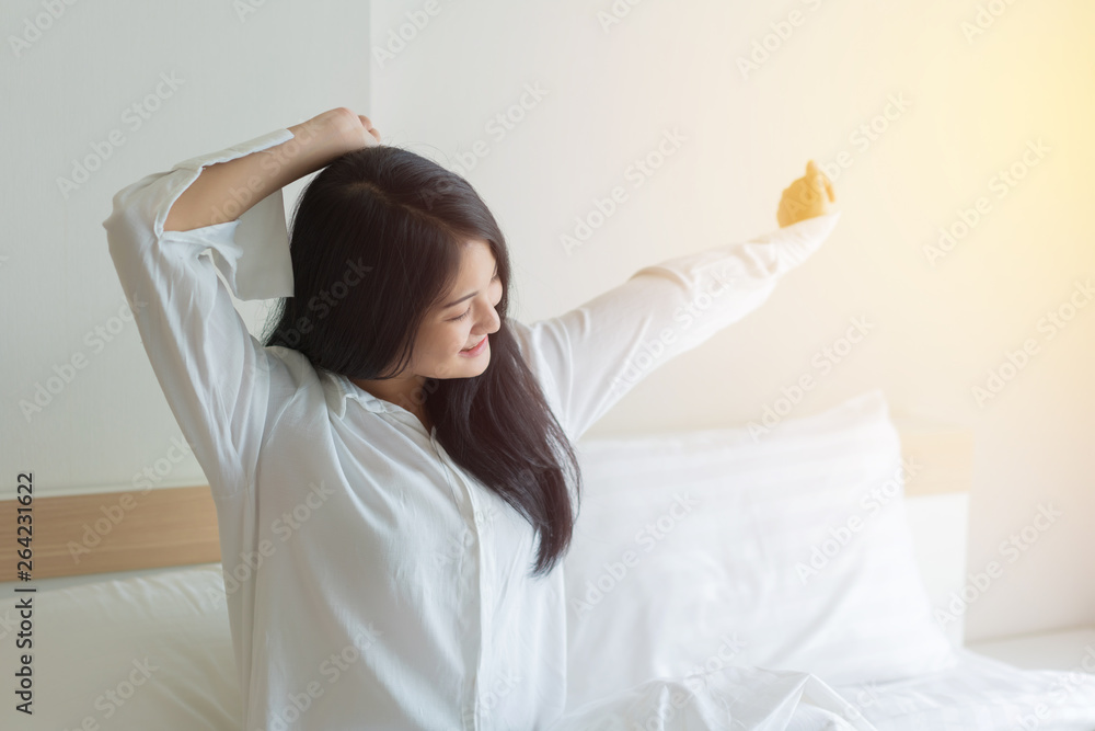 Beautiful young woman wake up and stretch oneself in the morning at bedroom Beautiful young woman wake up and stretch oneself in the morning at bedroom