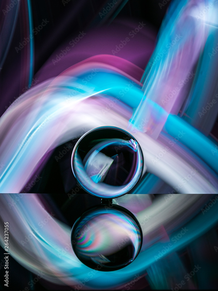 crystal ball on reflective surface with colorful lights background crystal ball on reflective surface with colorful lights background