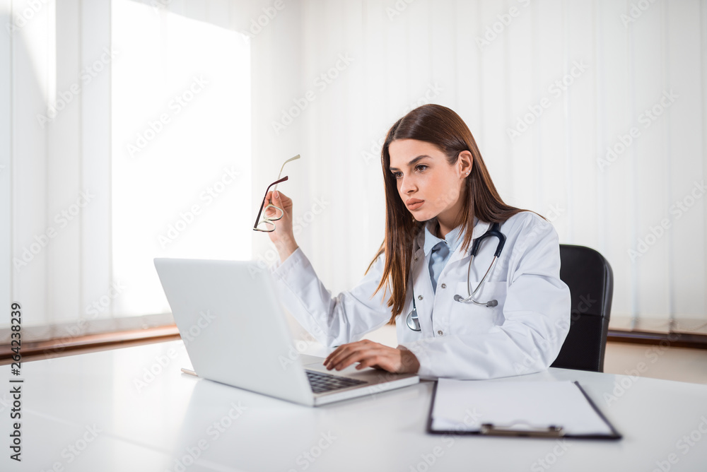 Brunette doctor looking concerned in bright office. Brunette doctor looking concerned in bright office.