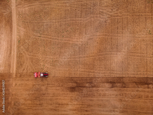 Quadro su tela Agriculture tractor plows field of land for sowing