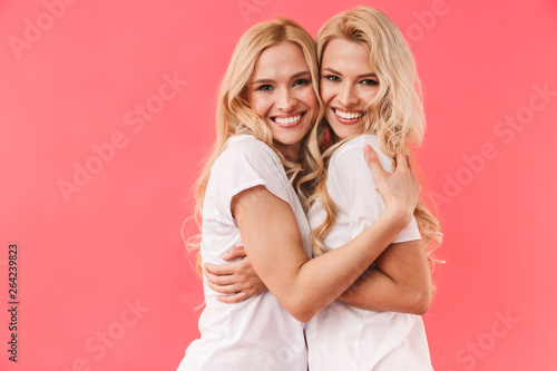 Happy blonde twins wearing in t-shirts hugging each other