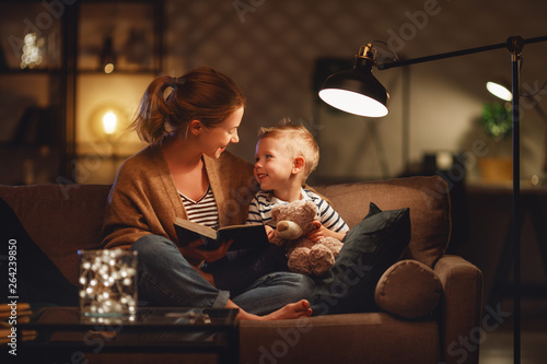 Foto Family before going to bed mother reads to her child son book near a lamp in the evening