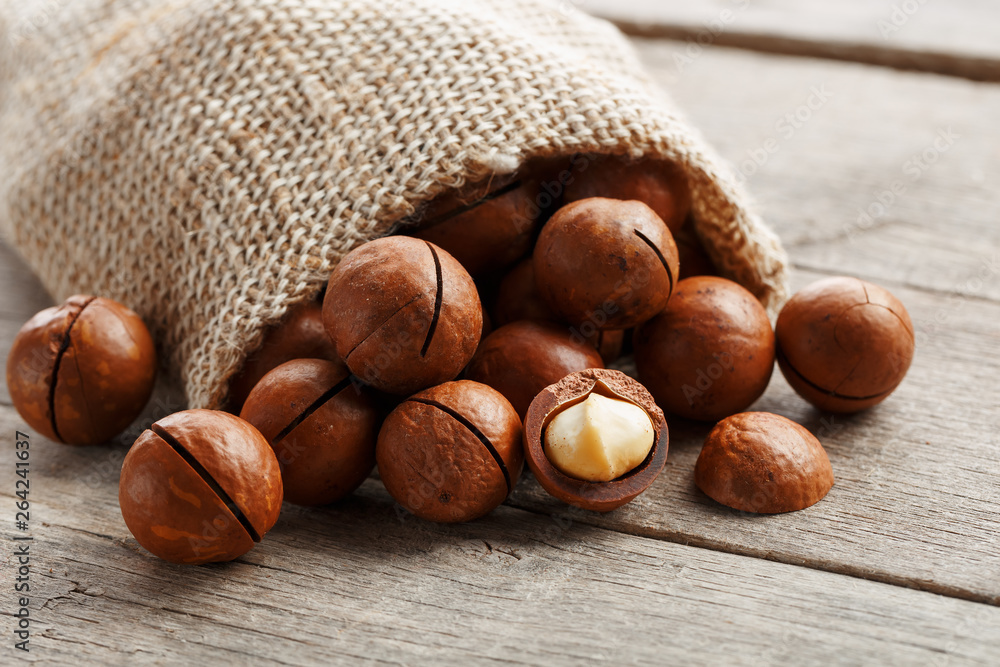 Macadamia nut on a wooden table in a bag, closeup, top view Macadamia nut on a wooden table in a bag, closeup, top view