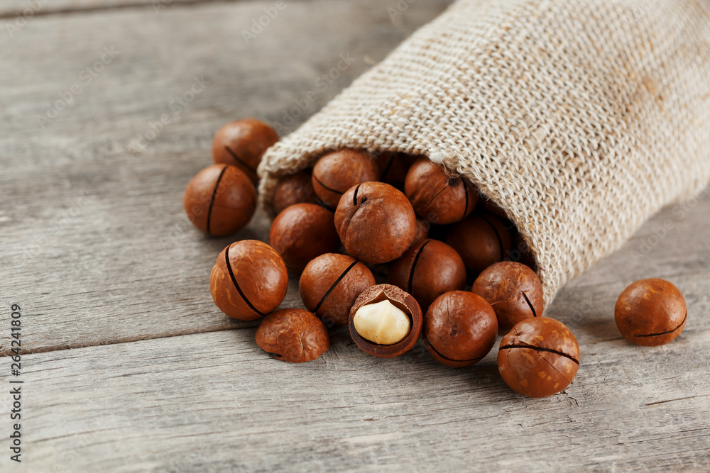 Macadamia nut on a wooden table in a bag, closeup, top view Macadamia nut on a wooden table in a bag, closeup, top view