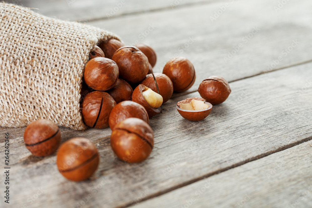 Macadamia nut on a wooden table in a bag, closeup, top view Macadamia nut on a wooden table in a bag, closeup, top view