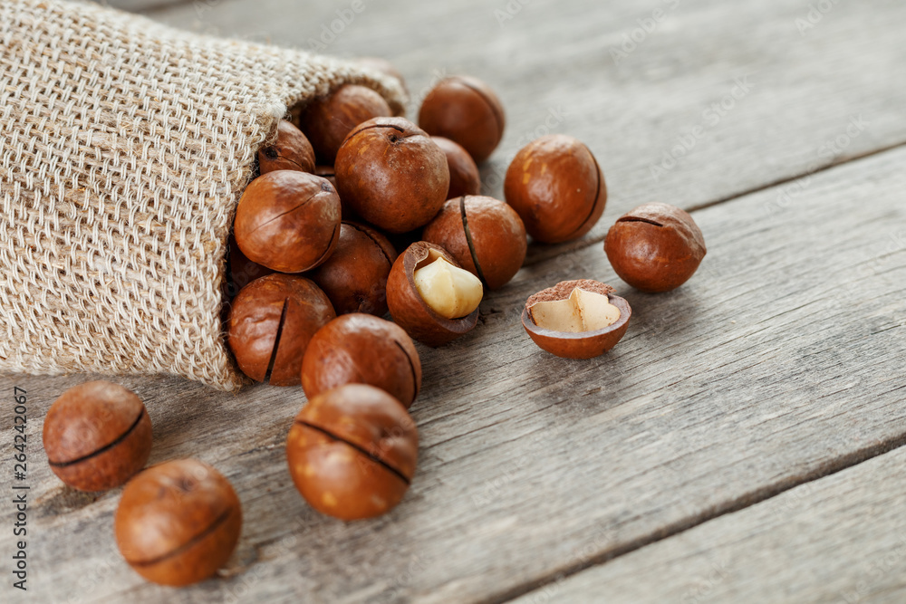Macadamia nut on a wooden table in a bag, closeup, top view Macadamia nut on a wooden table in a bag, closeup, top view