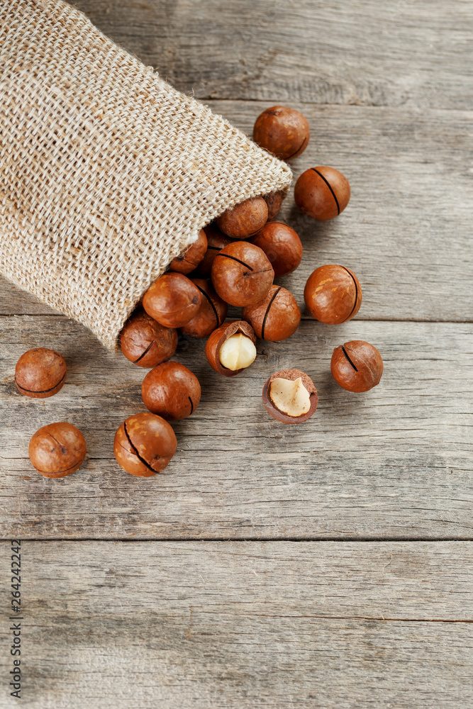 Macadamia nut on a wooden table in a bag, closeup, top view Macadamia nut on a wooden table in a bag, closeup, top view