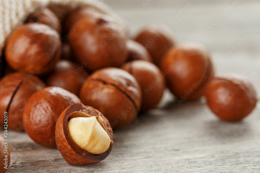 Macadamia nut on a wooden table in a bag, closeup, top view Macadamia nut on a wooden table in a bag, closeup, top view