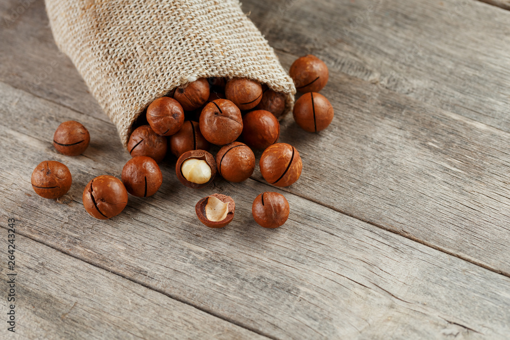 Macadamia nut on a wooden table in a bag, closeup, top view Macadamia nut on a wooden table in a bag, closeup, top view