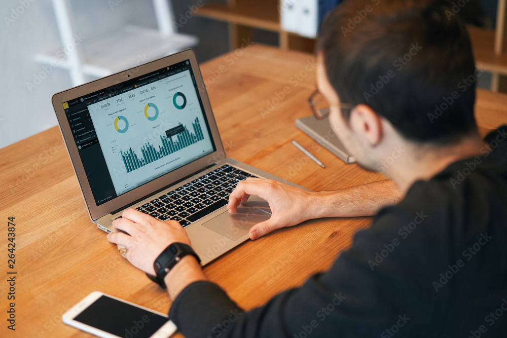 Closeup of man working on laptop with finances or ceo, graph, business analytics and strategy Closeup of man working on laptop with finances or ceo, graph, business analytics and strategy