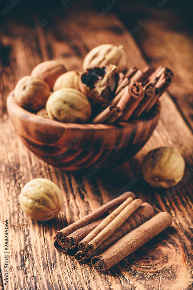 Cinnamon sticks and dried limes in wooden bowl Cinnamon sticks and dried limes in wooden bowl