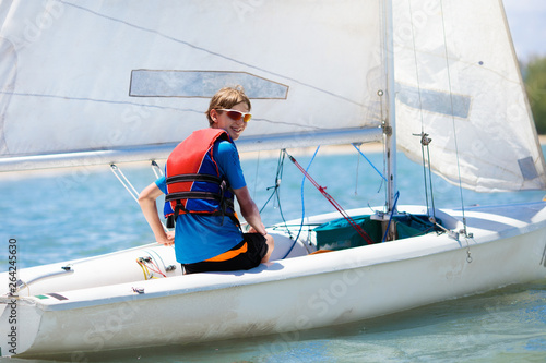 Child sailing. Kid learning to sail on sea yacht.