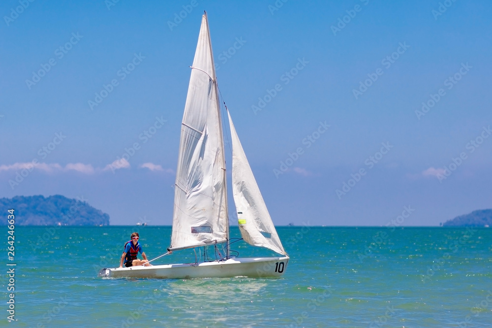 Naklejka premium Żeglujący mężczyzna. Chłopiec uczy się pływać na jachcie morskim.