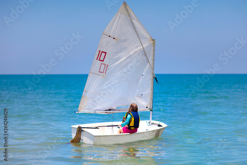 Child sailing. Kid learning to sail on sea yacht.