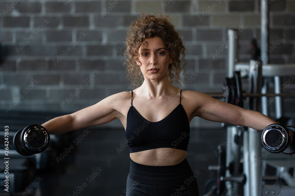 Fototapeta premium Handsome girl workout in gym