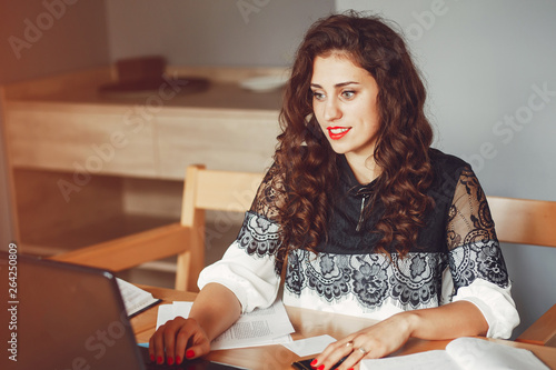 Beautiful girl in the office. Woman is working. A woman with curly hair