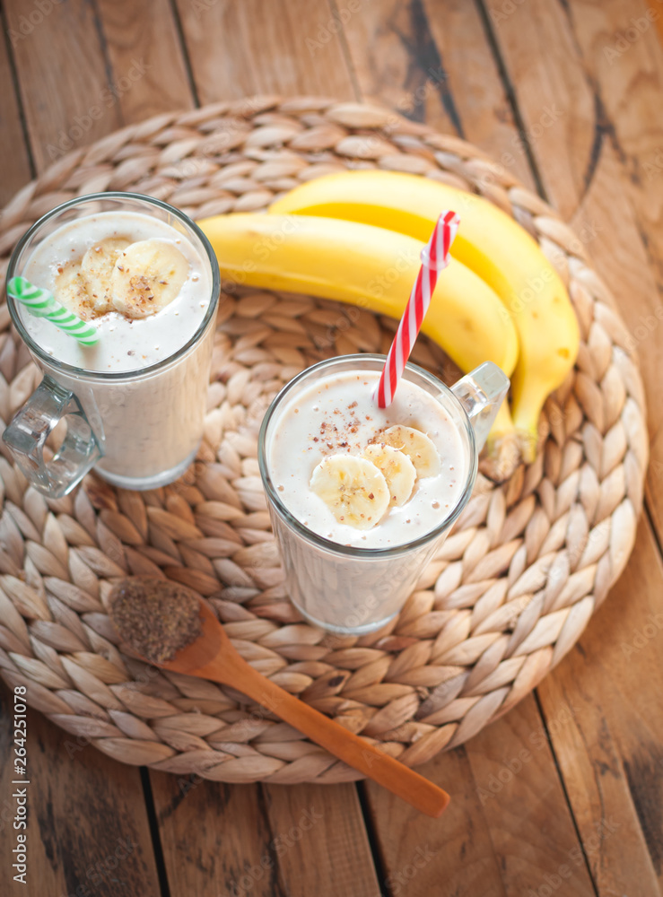 Close-up of banana and flax seeds smoothie in a glass on wooden background