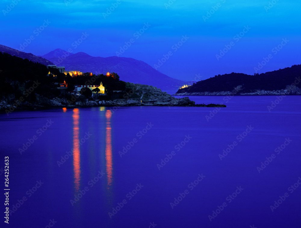 Moody landscape. Evening at the Mediterranean Sea with a view on the Dubrovnik lights, Lokrum island and distant mountains.