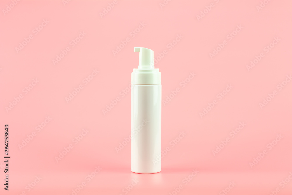 White plastic cosmetic lotion bottle on pink background. White plastic cosmetic lotion bottle on pink background.
