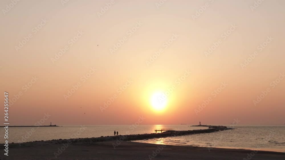 Lighthouse during a last minute of sunset with a big sun close to the horizon and clear sky Lighthouse during a last minute of sunset with a big sun close to the horizon and clear sky
