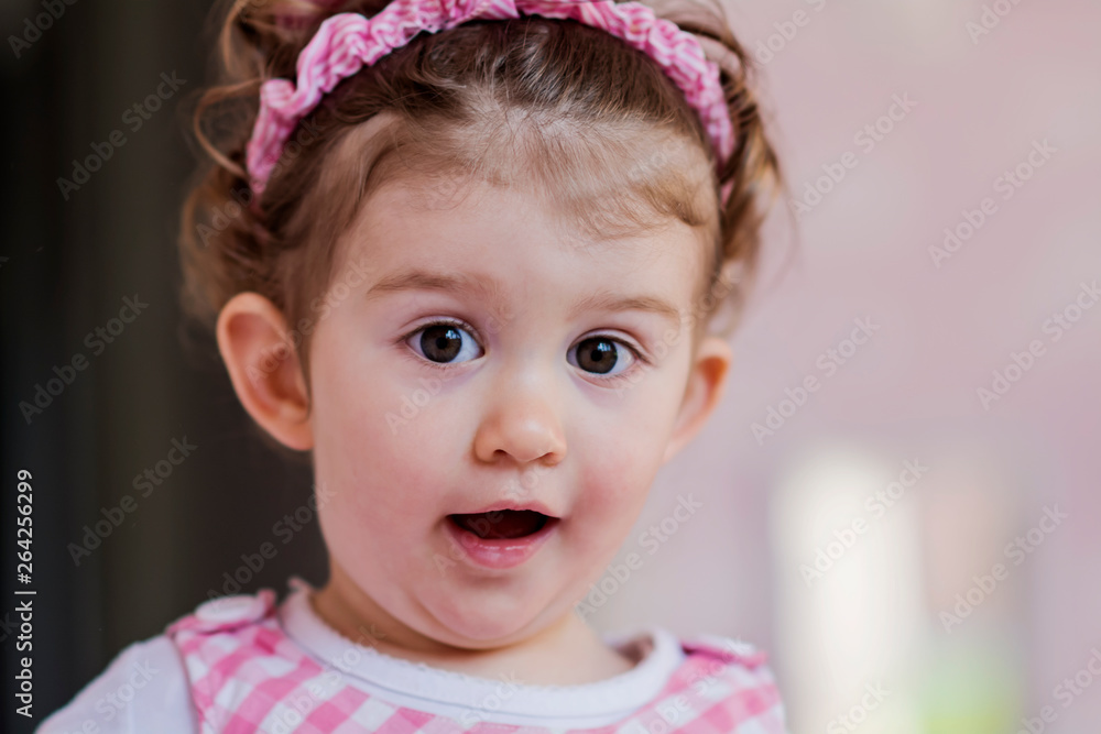 Portrait of Little Happy Girl with Curly Hair and Pink Dress.Close up of a Happy Smiling Child in a Pink Room Portrait of Little Happy Girl with Curly Hair and Pink Dress.Close up of a Happy Smiling Child in a Pink Room
