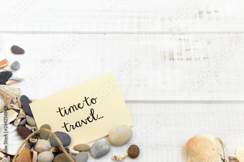 time to travel text words, summer sea shells, wooden white background, map