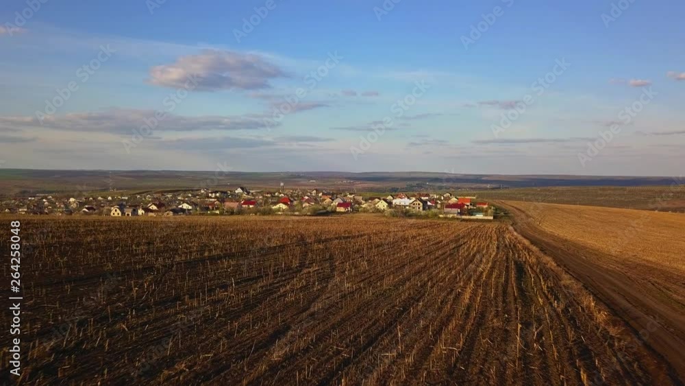 Sunset light over cultivating field and small village in the spring. Moldova Republic of. Sunset light over cultivating field and small village in the spring. Moldova Republic of.