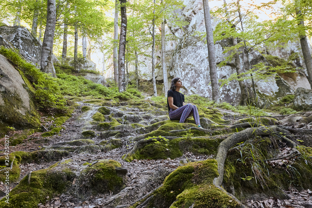Young attractive girl sit on the big rock in forest Young attractive girl sit on the big rock in forest