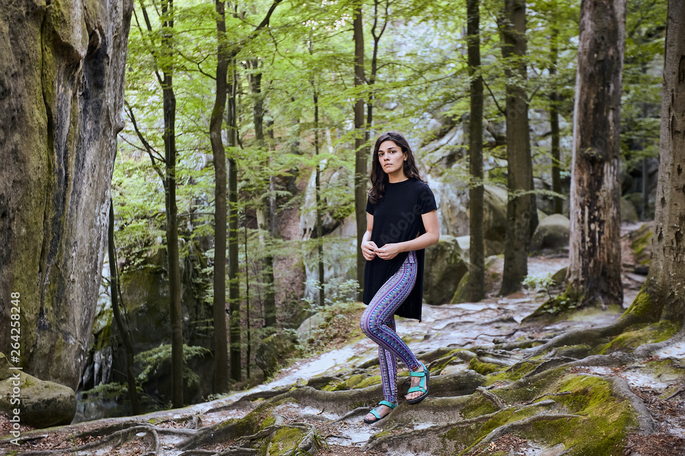 Young attractive girl stand between trees in forest Young attractive girl stand between trees in forest