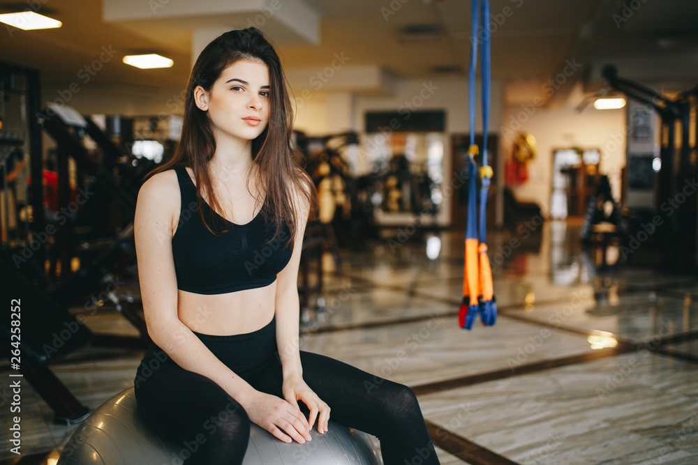 Beautiful girl in the gym. A woman performs exercises. Girl with a ball Beautiful girl in the gym. A woman performs exercises. Girl with a ball