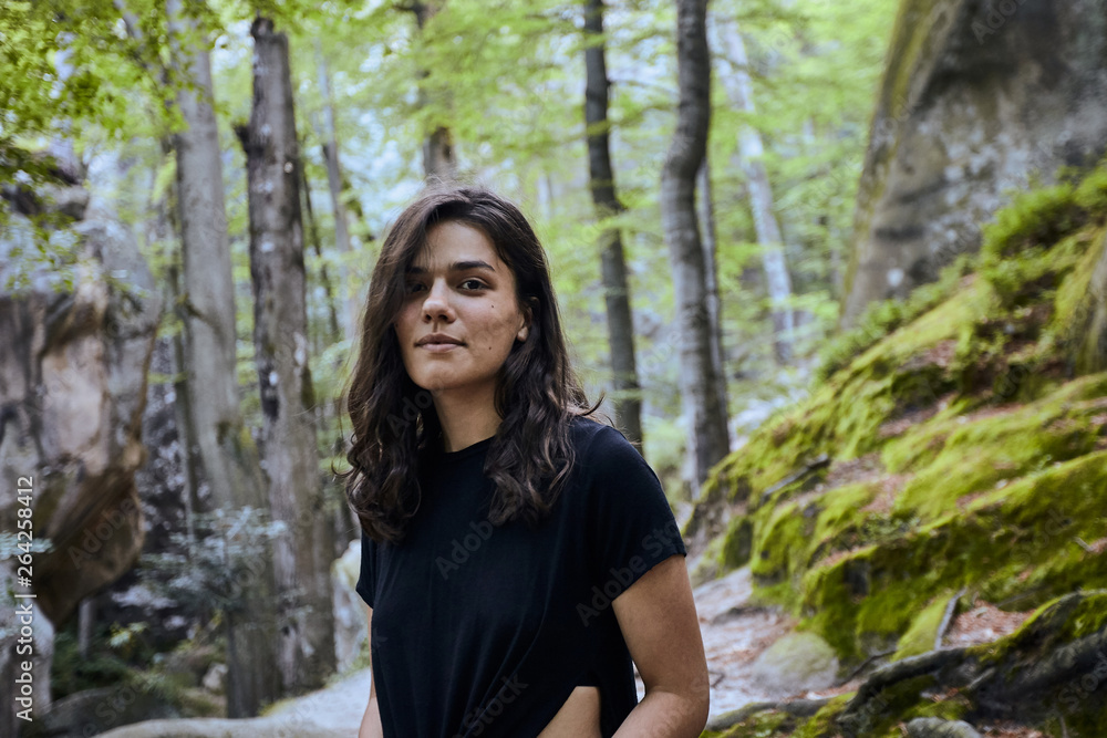 Young attractive girl stand between trees in forest Young attractive girl stand between trees in forest