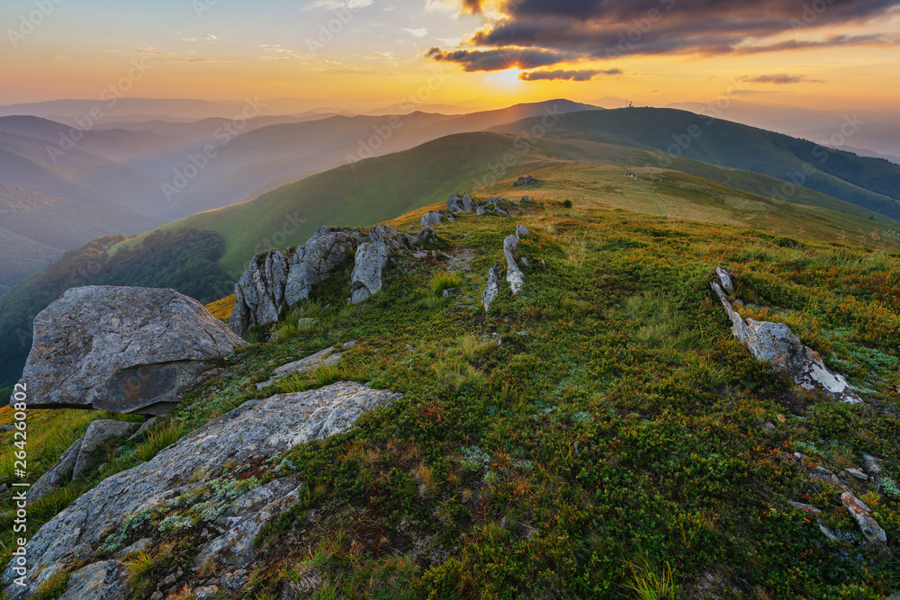 Mountain scenery in the Ukrainian Carpathians in the summer with a tourist in the background of the sunset
