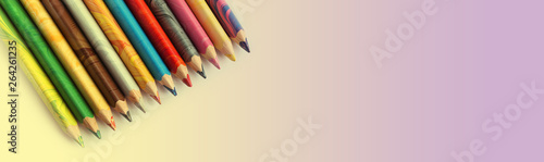 Color pencils on a multicolour background. Spectrum of a rainbow. Back to school. Selective focus, close-up. Banner.