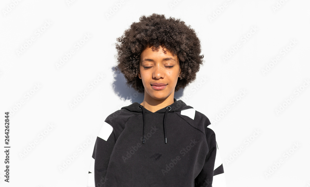 Fototapeta premium Women with Afro-black hair in front of white wall