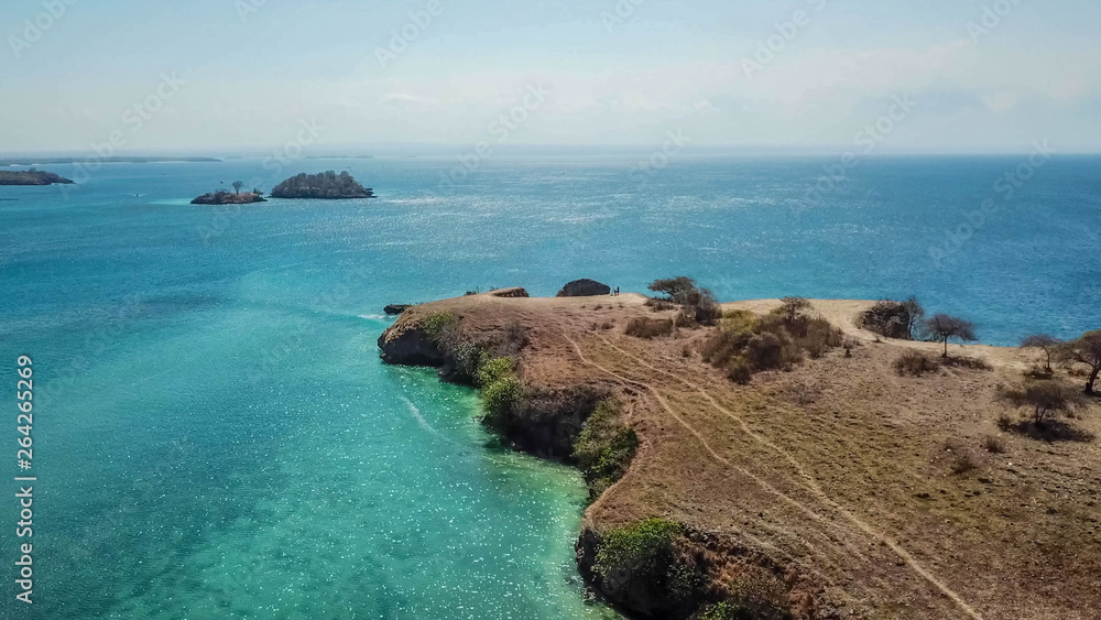 Tall cliffs captured with a drone from above in the nearby of Pink Beach, Lombok, Indonesia. Smooth capture, crystal clear water. Feeling of calm and rest. Holidays remedy. Vacation paradise. 