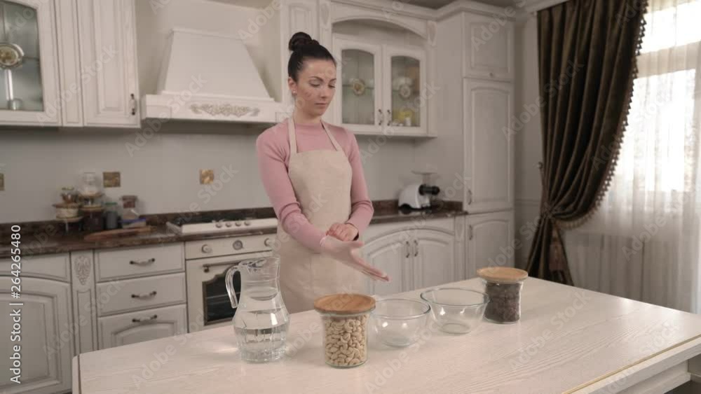 A beautiful young woman wearing culinary gloves before cooking in the kitchen. A beautiful young woman wearing culinary gloves before cooking in the kitchen.