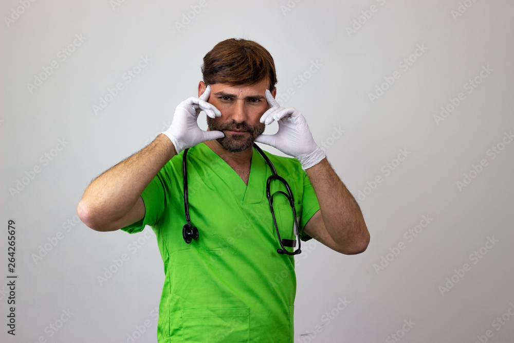 Portrait of male veterinary doctor in green uniform with brown hair looking concentrated, their back facing the camera and looking at the camera. Isolated on white background. Portrait of male veterinary doctor in green uniform with brown hair looking concentrated, their back facing the camera and looking at the camera. Isolated on white background.