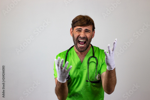 Fotografie Portrait of male veterinary doctor in green uniform with brown hair looking euphoric, looking at the camera