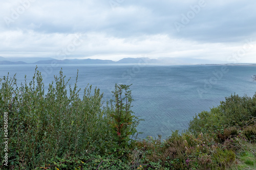 Blue natural background with clouds, mountains sea and vegetation