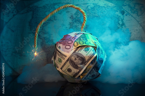 The world of money is burning.Financial bomb explodes.Smoke,fuse.Dollar and Euro decrease. Global economic recession concept.World map in the background.