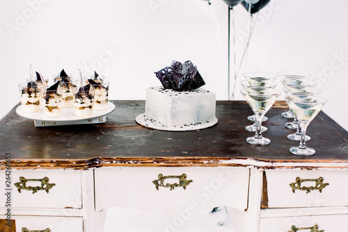 Party celebration concept, food and desserts. Tasty birthday cake, tiramisu desserts and alcohol drinks on the vintage wooden table