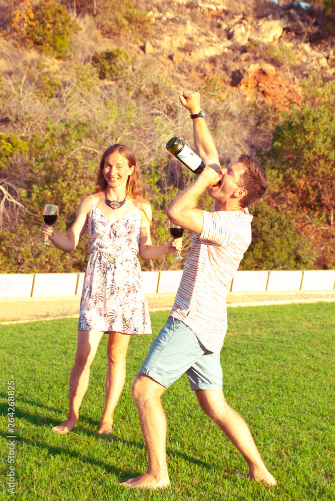 Obraz premium Man gives a concert for his woman with bottle of wife. Time of humor.